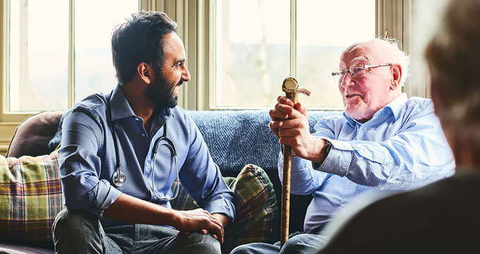 Doctor and older an sitting on a couch and talking