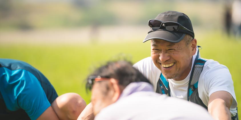 Group of men sitting in field laughing