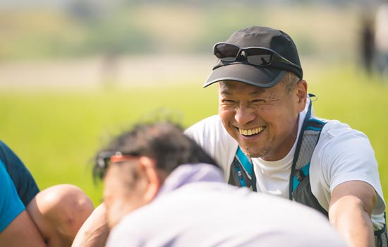 Group of men sitting in field laughing